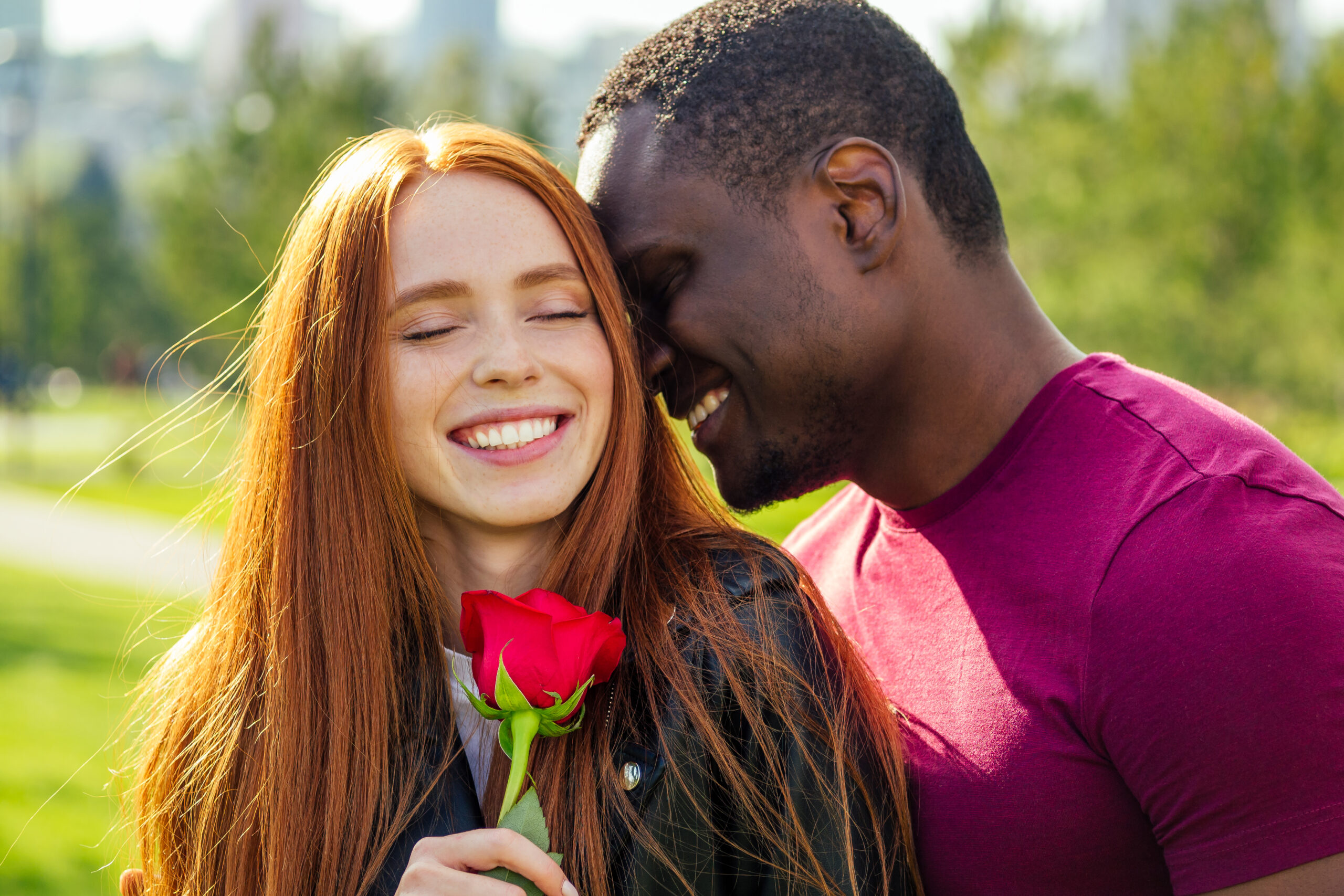 Find Love as a Redhead - interracial couple holding a rose