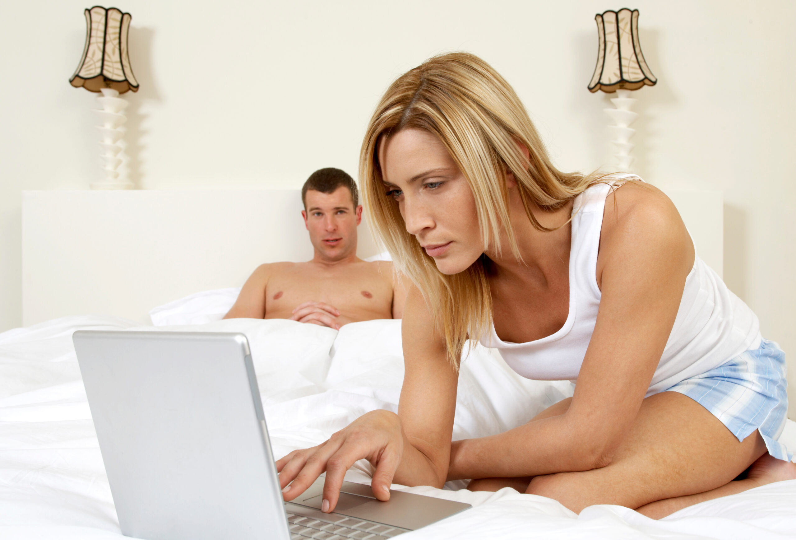 How to Spot Obsessive Ex-Girlfriend Behaviour Before It Goes Too Far - woman on laptop and man in bed